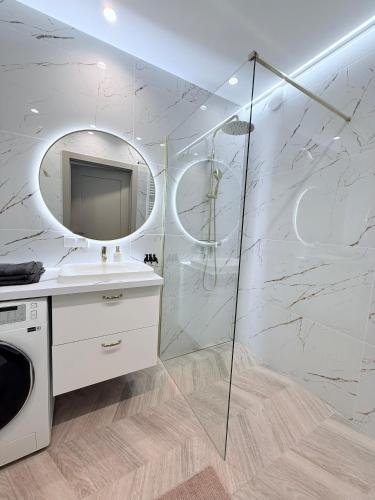 a bathroom with a sink and a mirror at Kapitańska Przystań - basen & sauna & jacuzzi & klimatyzacja & garaż in Dziwnów