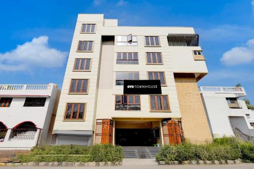 a tall white building with a sign on it at Super Collection O Vellore Near CMC Hospital Formerly Geetha Residency in Vellore