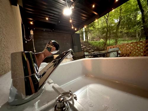 a bathroom sink with a mirror over a sink at Gen-en Private Hideaway Villa, Izu Forest in Izu