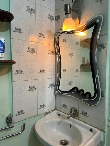 a bathroom with a sink and a mirror at Peaceful Family Bungalow Near Mahalakshmi Temple in Kolhapur