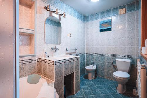 a bathroom with a sink and a toilet and a tub at Penzion UNA in Liptovský Ján