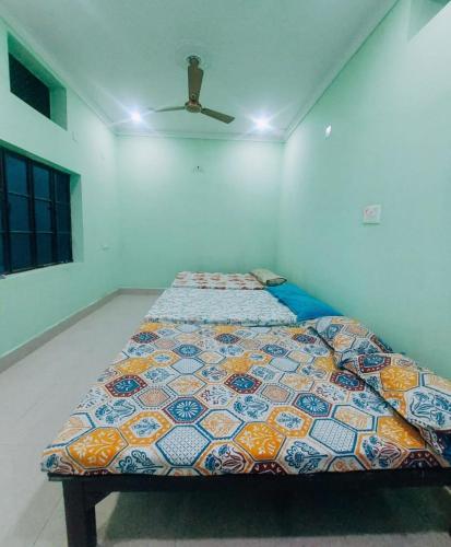 a bed in a room with a ceiling fan at Anand Nivas Homestay 10 Mins from Mandir in Deoghar