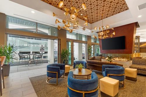 a lobby with a table and chairs and a tv at Cambria Hotel Philadelphia Downtown - Center City in Philadelphia