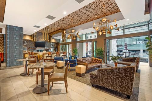 a lobby of a restaurant with tables and chairs at Cambria Hotel Philadelphia Downtown - Center City in Philadelphia