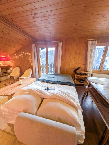 a large bed in a room with wooden walls at Cocon Alpin: Vue Imprenable, Central & Calme in Saint-Luc