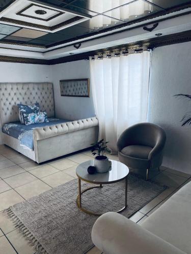 a living room with a bed and a table and a chair at Euphoria Escape in Midrand
