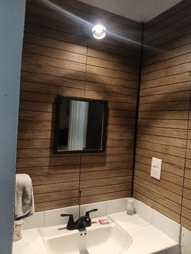 a bathroom with a sink and a television on a wall at Casa Ambar 2 recamaras,aire acondicionado y factura in Nogueras