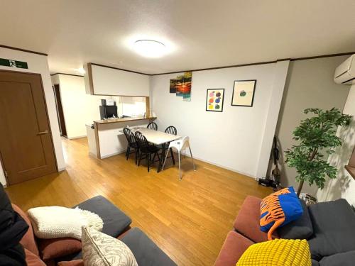 a living room with a couch and a table with chairs at モニンハグ旭3 in Osaka