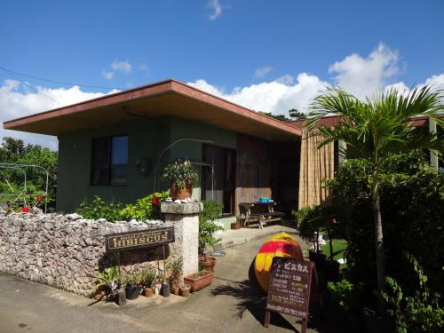 a house with a sign in front of it at Hotel Hibiscus in Miyako-jima