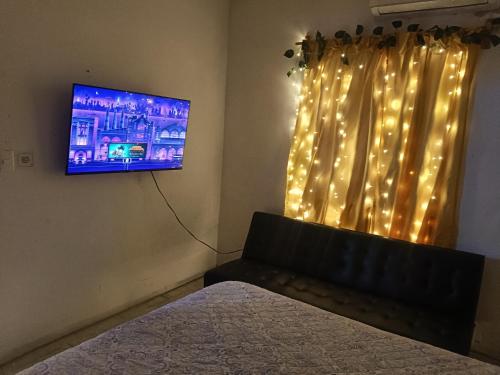 a bedroom with a bed and a tv and a window at Casa Ambar 2 recamaras,aire acondicionado y factura in Nogueras