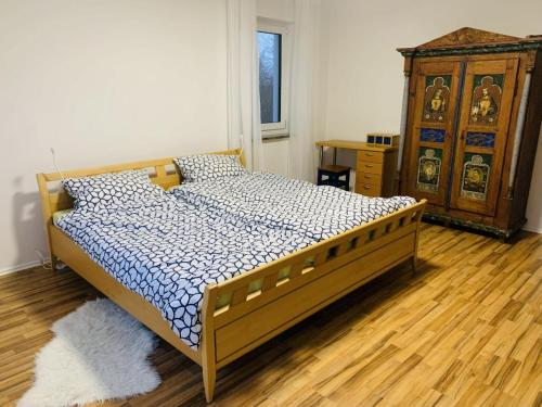 a bedroom with a bed and a wooden dresser at FeWo Landblick in Hemau