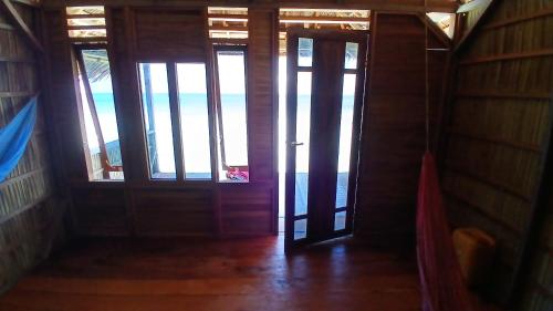 an open door with a view of the ocean at Homestay Yenkop in Poelau Mansoear