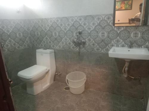 a bathroom with a toilet and a sink at Hotel Vaishnavi in Hyderabad