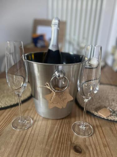 a bucket of wine with two wine glasses on a table at Entire Private Apartment with Kitchen and Lounge in Braybrooke