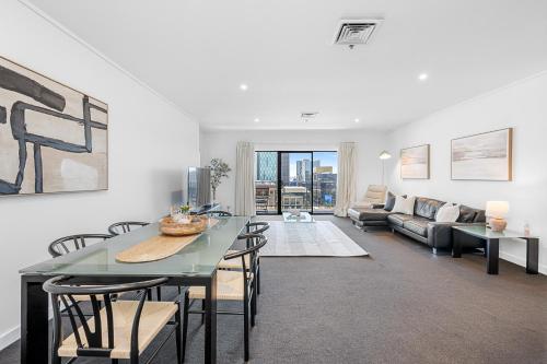 a living room with a table and chairs and a couch at Barrack Street City Pad 2br 2 Bth in Perth