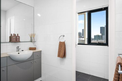 a white bathroom with a sink and a window at Barrack Street City Pad 2br 2 Bth in Perth