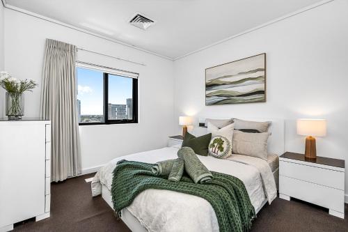 a white bedroom with a bed and a window at Barrack Street City Pad 2br 2 Bth in Perth
