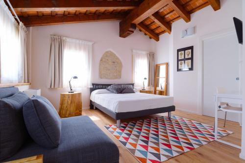 ein Schlafzimmer mit einem Bett und einem Sofa in der Unterkunft B&B Mulino di Campese in Campese