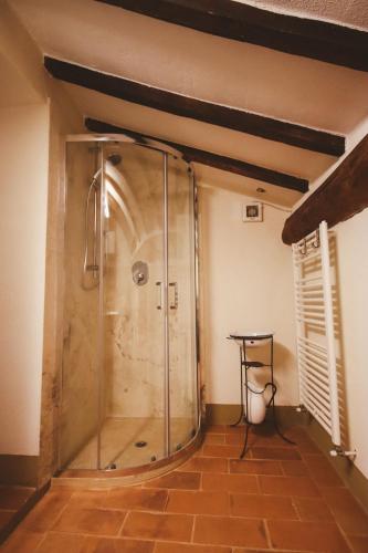 a shower with a glass door in a room at Ca 18 rooms in Lucignano