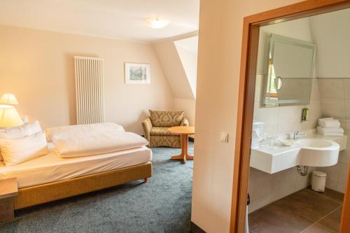a hotel room with a bed and a sink at Hotel Kloster Nimbschen 4 Sterne in Grimma