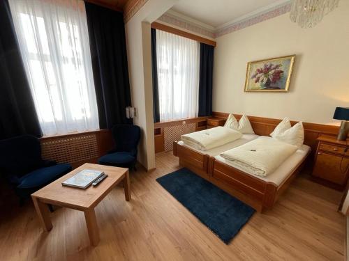 a hotel room with a bed and a table at Cityhotel Ratheiser in Klagenfurt