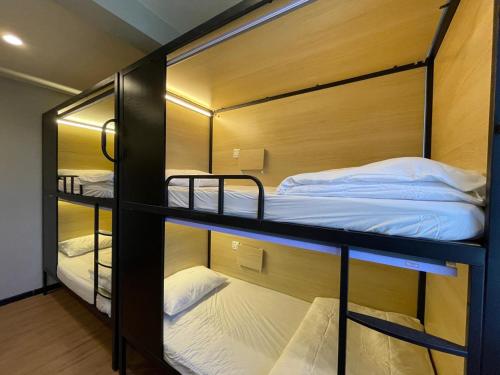 a room with three bunk beds in it at Mini Urban Guest House in Kampong Pasang