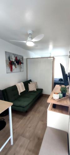 ein Wohnzimmer mit einer grünen Couch und einem Tisch in der Unterkunft Auszeitbox in Schärding