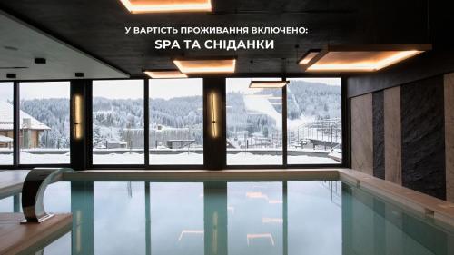 a swimming pool with a view of a ski resort at Didukh Eco Hotel&Spa in Bukovel