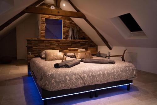 a bedroom with a large bed in a attic at Love Room Evasion Jacuzzi Sauna Hamamm in Saint-Cyr-sur-Loire
