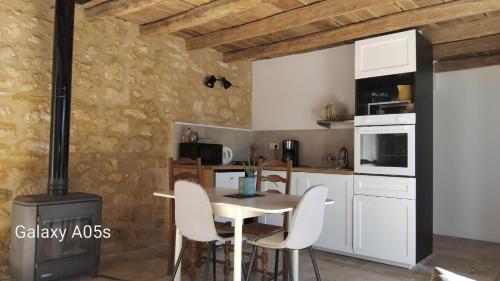 une cuisine avec une table, des chaises et une cuisinière dans l'établissement Chez Anaïs, à Cénac-et-Saint-Julien