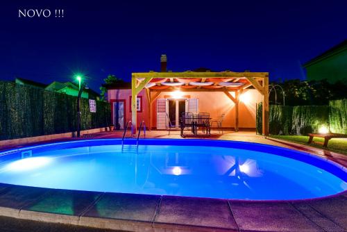 a swimming pool in a backyard at night at Holiday home Orange with heated pool and parking in Zadar
