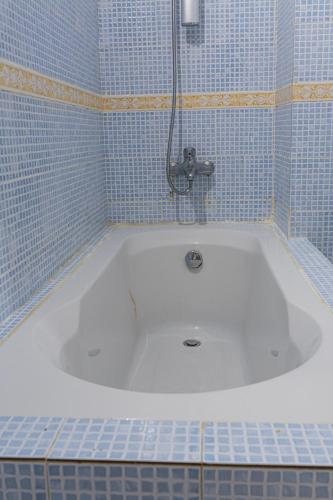 a bath tub in a bathroom with blue tiles at Camara Homes1 in Saint-Louis
