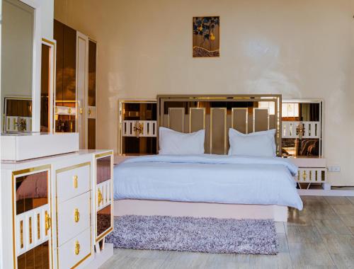 a bedroom with a large white bed with a large headboard at Camara Homes1 in Saint-Louis