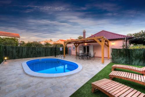 a swimming pool in the middle of a yard at Holiday home Orange with heated pool and parking in Zadar