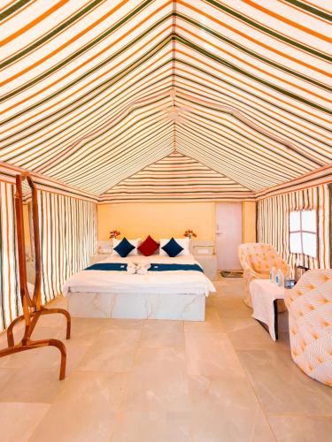 a bedroom with a bed and a striped ceiling at Jaisalmer Villa Resort & Camp Jaisalmer in Jaisalmer