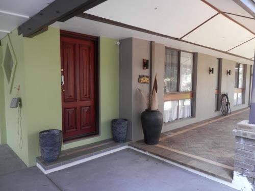 a front door of a house with a vase next to it at The Hideaway Luxury B&B Retreat in Armadale