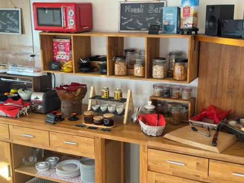 a kitchen with wooden shelves with food on them at Pension Bergseeblick in Titisee-Neustadt