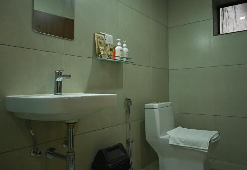 a bathroom with a sink and a toilet at Abad Silver Mist in Vagamon