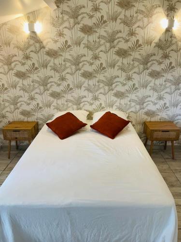 a bed with two pillows on it in a bedroom at L entre deux charentes in Montils