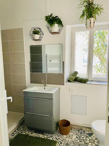 a bathroom with a sink and a mirror at L entre deux charentes in Montils