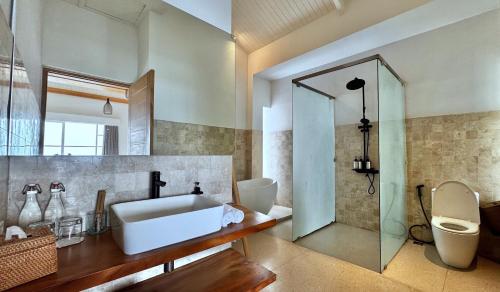 a bathroom with a sink and a shower and a toilet at Nalas Villa in Ketewel