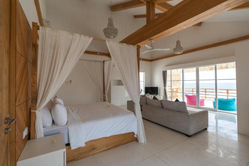 a bedroom with a canopy bed and a couch at Nalas Villa in Ketewel