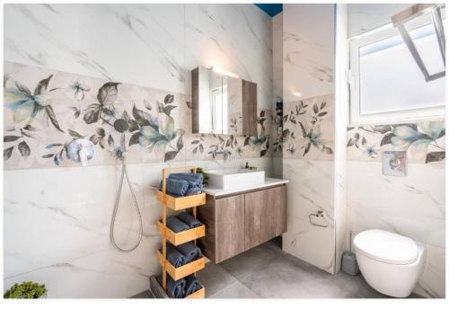 a bathroom with a sink and a toilet at Restaurant Maria Suites SunSet in Faliraki