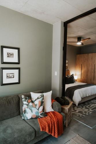 a living room with a couch and a bed at IBella's at The Urban in Pretoria