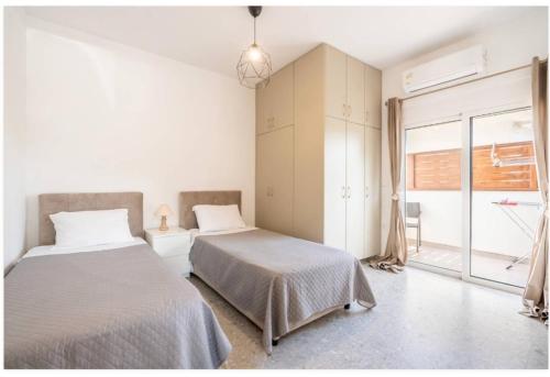 a bedroom with two beds and a window at Restaurant Maria Suites SunSet in Faliraki
