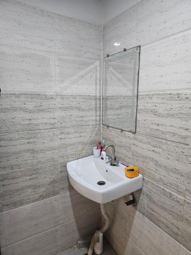 a white bathroom with a sink and a mirror at the varun residency in Greater Noida