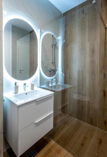 a bathroom with a white sink and a mirror at Velora Apartments in Năvodari
