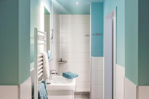 a bathroom with a white sink and a mirror at Hotel Klein Amsterdam in Friedrichstadt