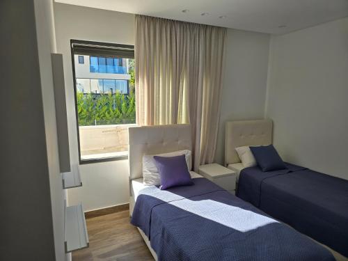 a hotel room with two beds and a window at Villa rooftop with stunning view apartment in Amman