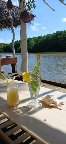 a table with a glass vase with a flower in it at Ginger Harmony Tangalle Lagoon View in Tangalle